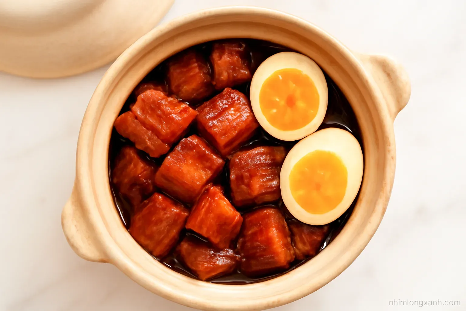 Top-down view of a clay pot of glossy caramel braised pork belly with halved duck eggs on a white marble counter, soft morning window light, warm amber and cream palette
