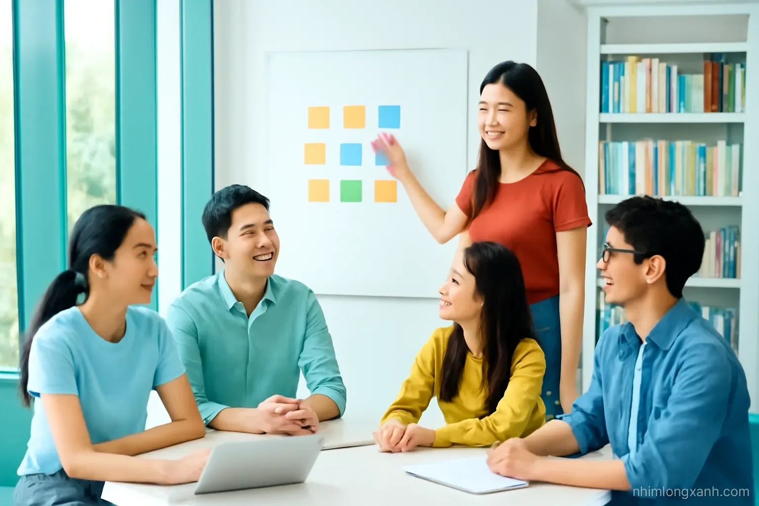 Wide shot of five Vietnamese university students around a round table in a bright library corner, a young woman standing and pointing at colorful sticky notes, warm daylight, teal accents