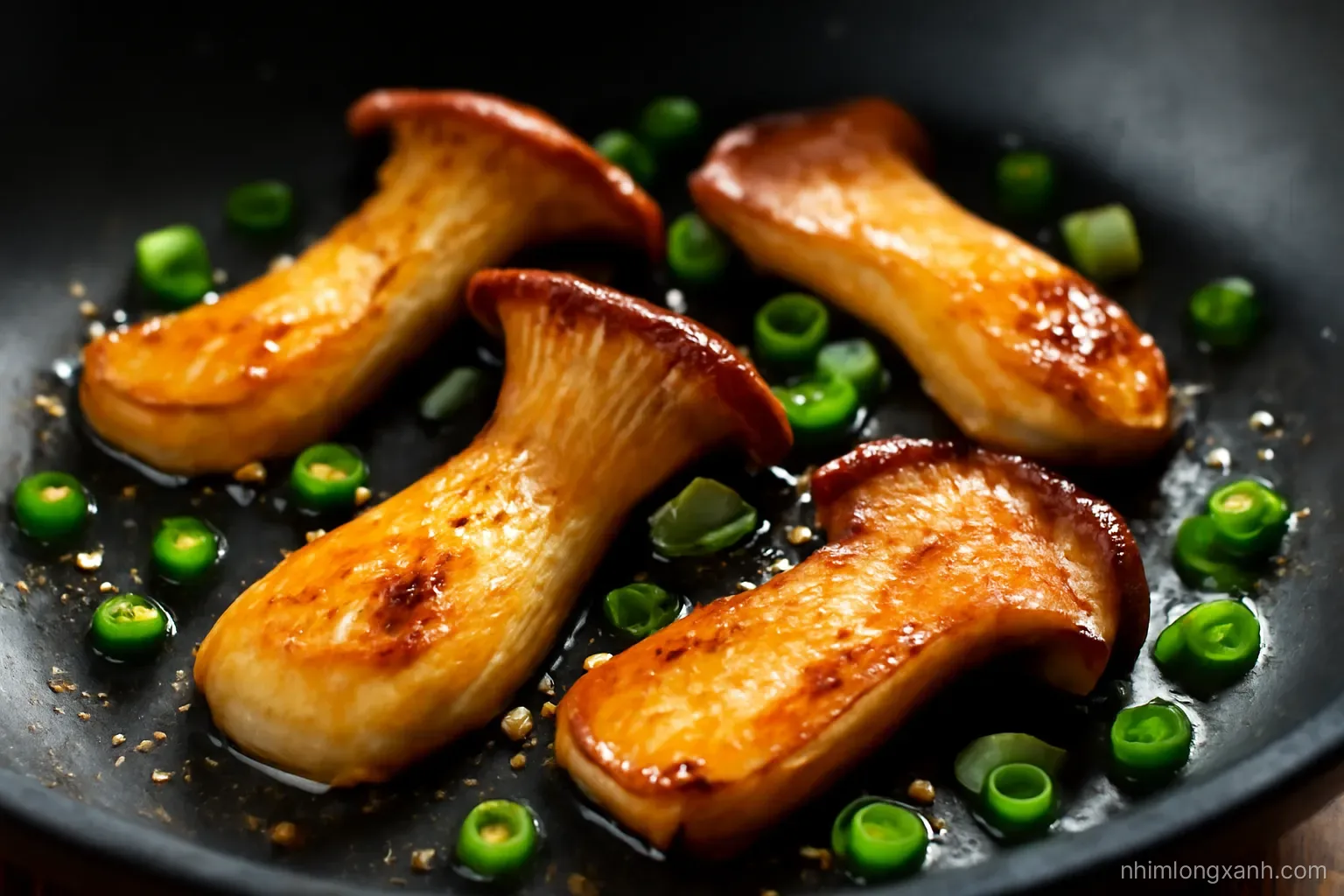 Close-up macro of king oyster mushrooms searing golden in a black wok with scattered green onions, droplets of oil glistening, dramatic warm side light, charcoal and amber palette