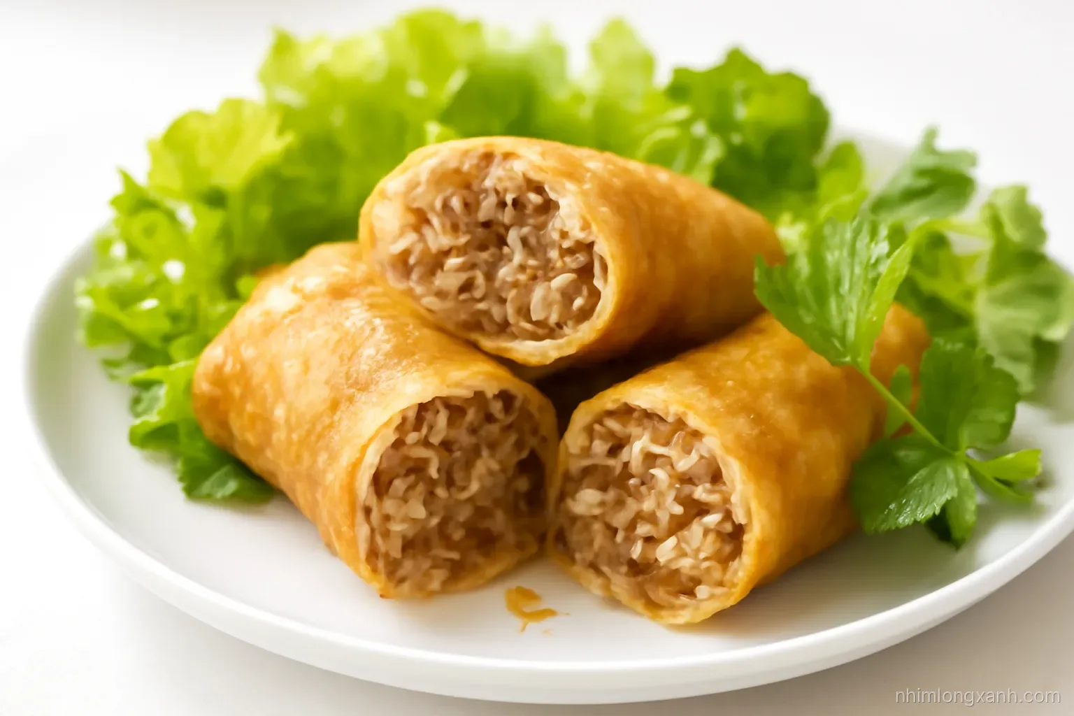 Macro close-up of golden crispy fried spring rolls cut in half revealing pork and glass noodle filling, lettuce and herbs around, bright white plate, warm amber and fresh green palette