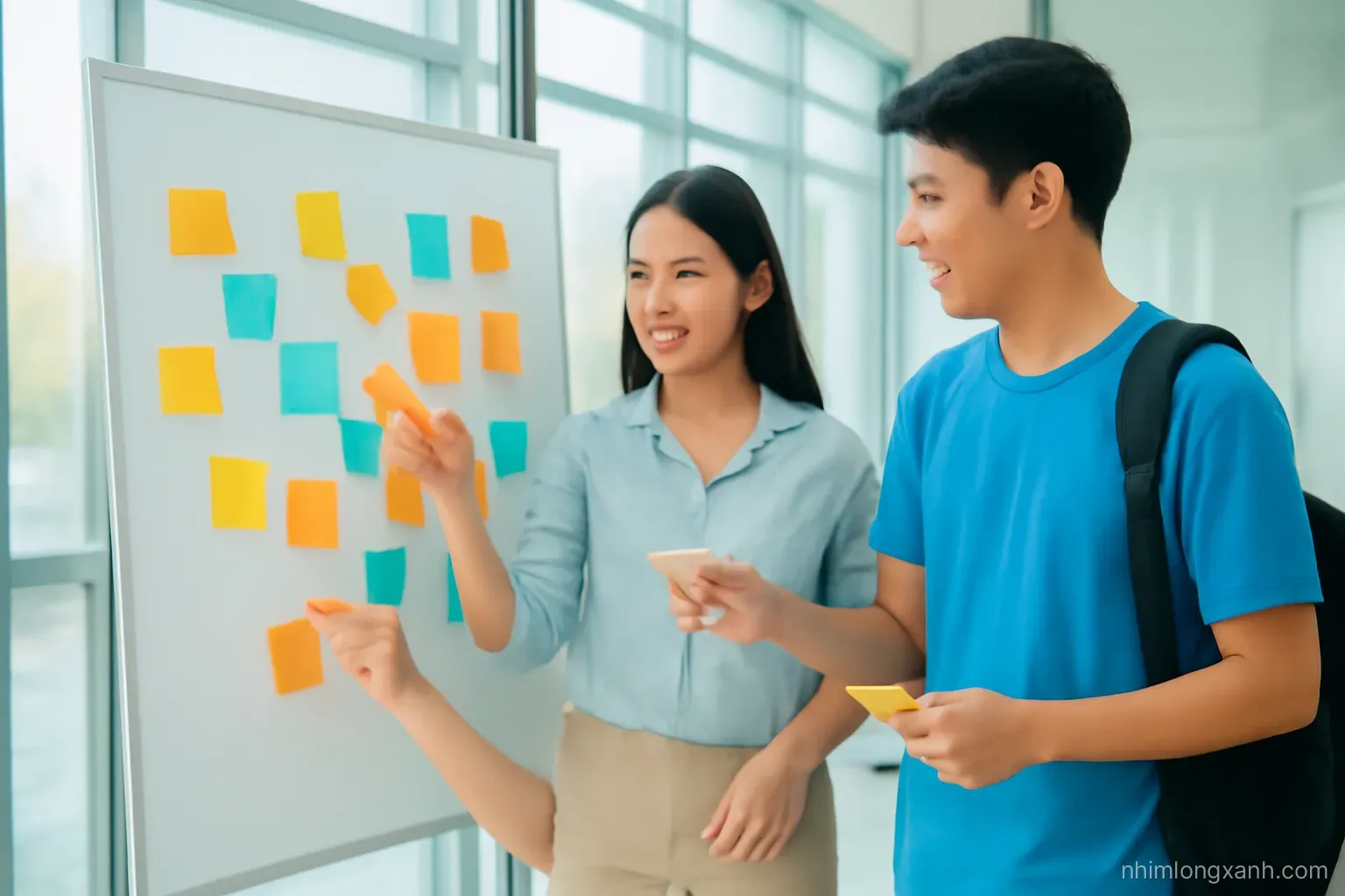 Three Vietnamese university students brainstorming around a whiteboard covered in abstract colorful sticky shapes in a glass-walled study room, eye-level medium shot, cheerful daylight, yellow and blue palette