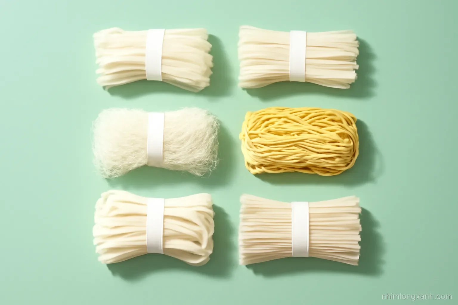 Flat lay of six bundles of Asian noodles arranged in a neat grid on a mint green tabletop, thick tapioca noodles, flat rice noodles, round vermicelli, yellow egg noodles, bright even daylight