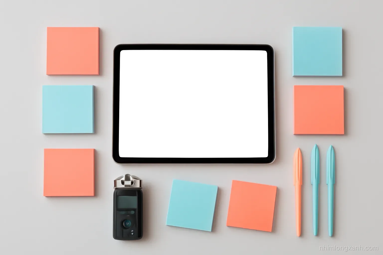 Top-down flat lay on a light grey desk: sticky notes clustered in groups beside a tablet with blank glowing screen, colored pens and audio recorder, crisp daylight, coral and slate blue palette