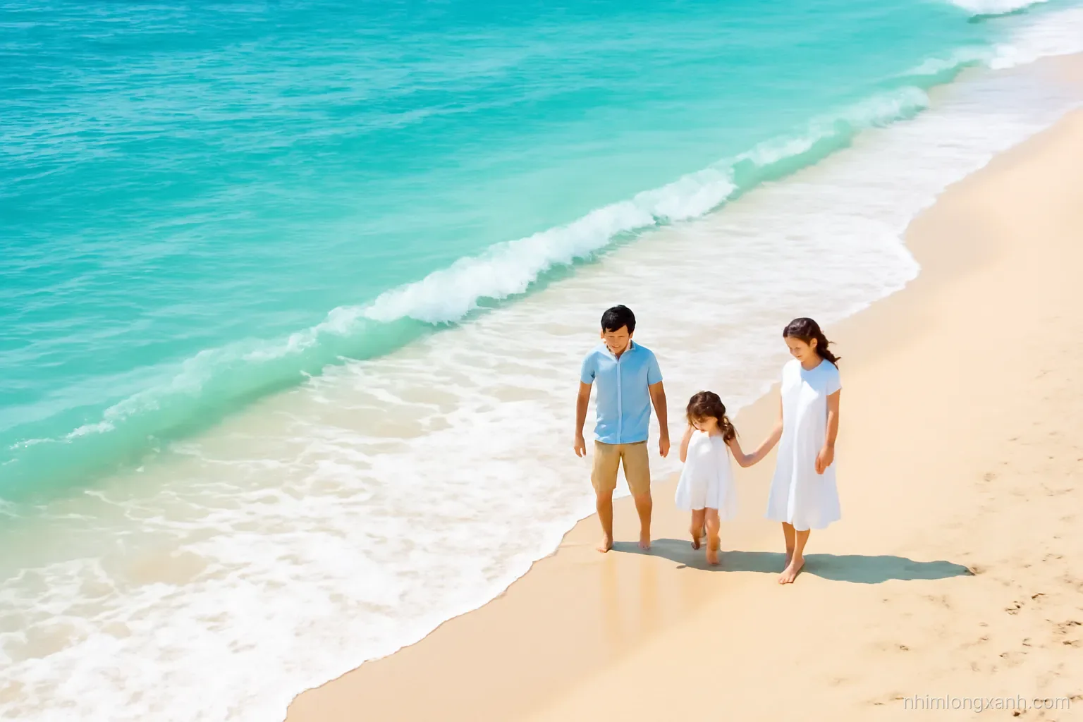 Wide aerial shot of turquoise sea waves rolling onto a pale sandy beach in central Vietnam, a Vietnamese family wading at the shoreline, crisp morning sun, teal and sand tones